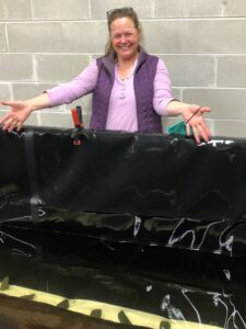 Smiling woman standing in front of black container