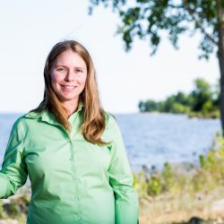 Smiling woman standing next to a tree