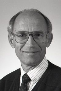 Close-up of man in a suit, tie and glasses