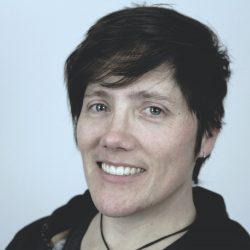 Closeup of smiling young woman with short dark hair.