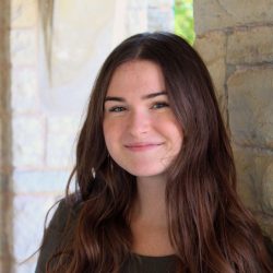 Close up of smiling person leaning against a wall