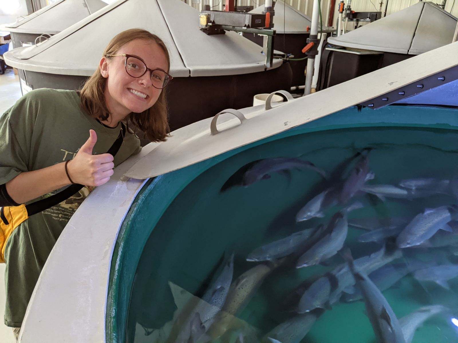 Jojo Hunt gives the thumbs up next to a large tank of fish 