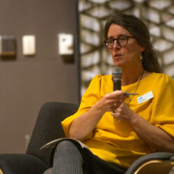 Seated person wearing a yellow shirt.