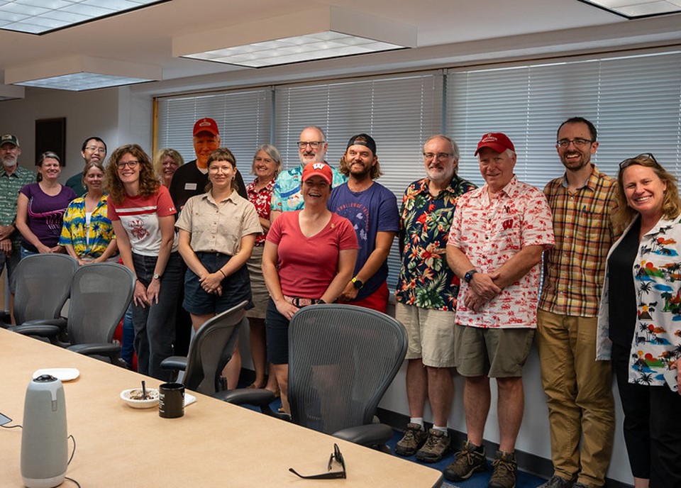 Hurley stands among a group of ASC colleagues posing for a photo 