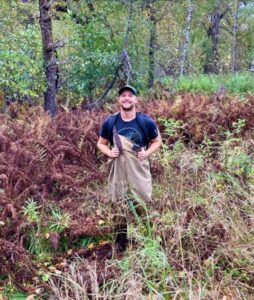 Person wearing waders and standing in brown and green vegetation. Submitted photo. 