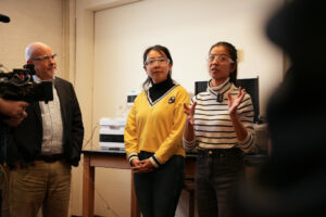 Three people standing in a line talking. 