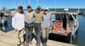Four members of the Great Lakes Eagle Health Project team standing on a dock.