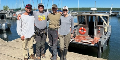 Four members of the Great Lakes Eagle Health Project team standing on a dock.