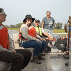 Project teams members smile during a discussion on the boat.