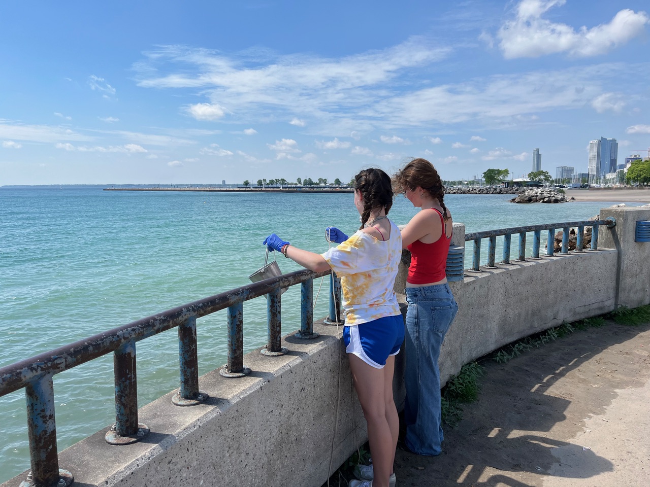 Two undergraduate students collect water samples from Lake Michigan