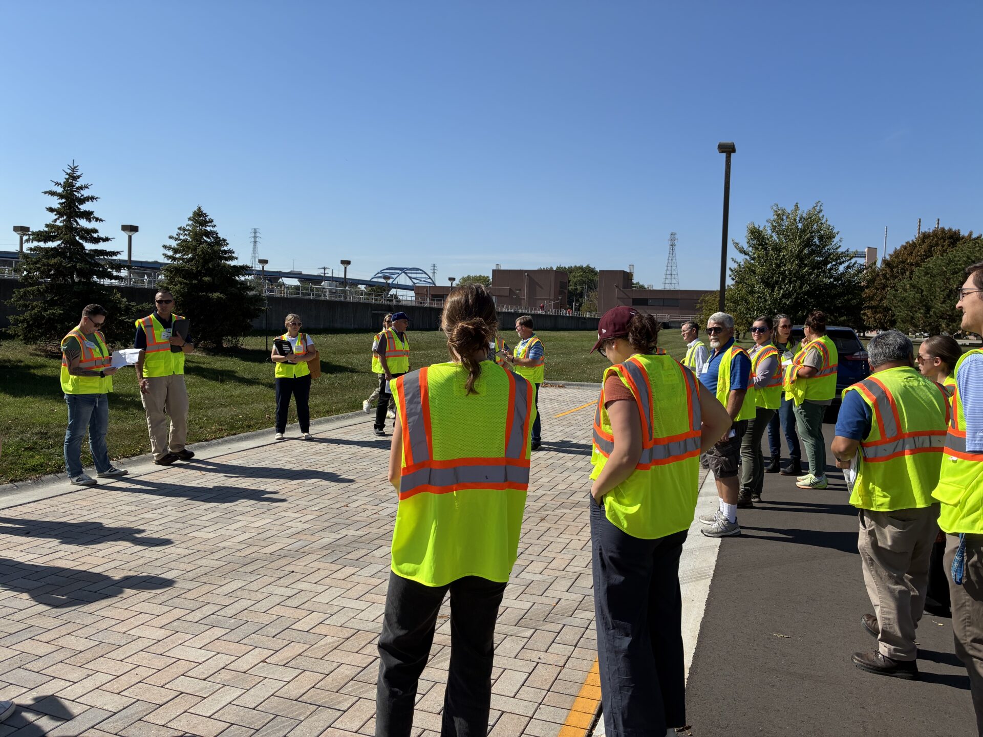 A tour group in high visibility vests looks at permeable pavement