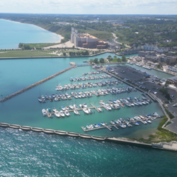 An aerial view of Port Washington Marina, showing boats floating in the light blue waters of Lake Michigan