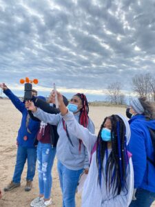 Middle school students taking weather measurements on Lake Michigan beach